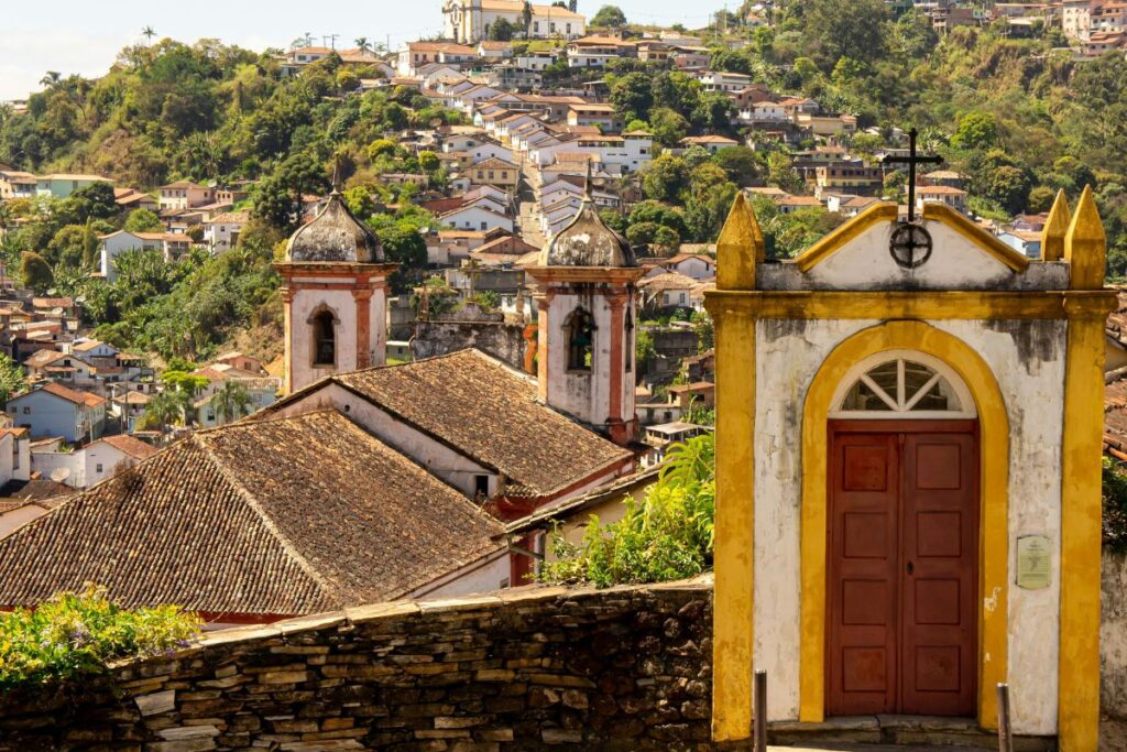 Imagem da vista panorâmica de Ouro Preto, em Minas Gerais, destacando o rico patrimônio cultural brasileiro, evidenciado pela arquitetura barroca, pelos monumentos religiosos e pelo conjunto urbano preservado. O cenário representa a importância da conservação da história, da arte e das tradições que fazem de Ouro Preto um dos principais destinos de turismo cultural do país.