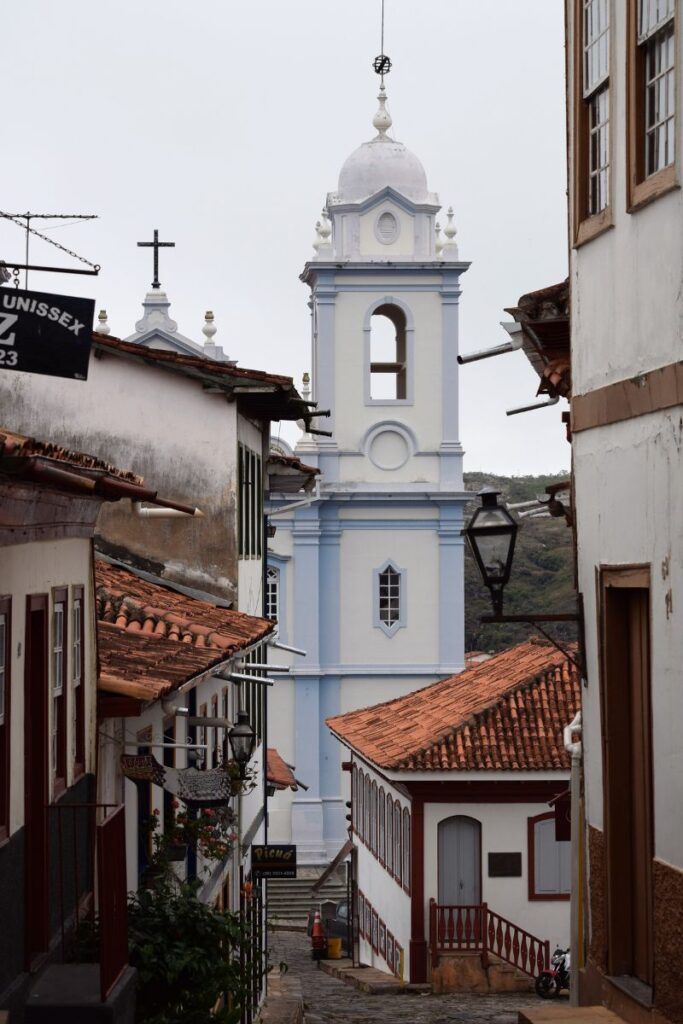 Torre azul e branca de igreja colonial cercada por telhados antigos em Diamantina, cidade histórica de Minas Gerais e Patrimônio Mundial da UNESCO