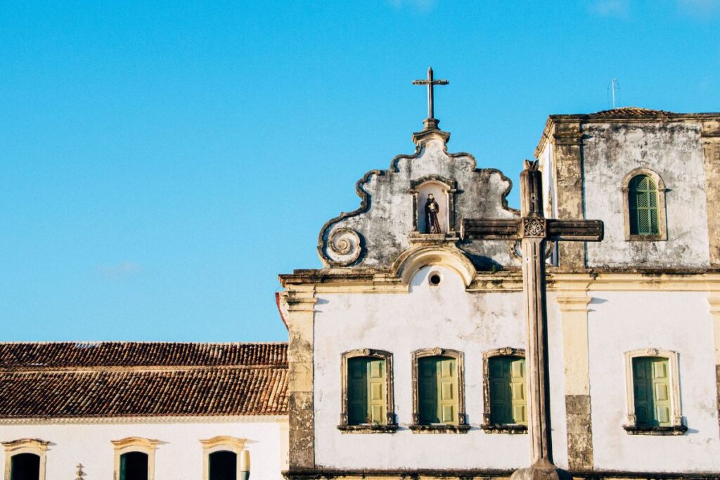 Fachada barroca de igreja colonial com cruz de pedra em São Cristóvão, Sergipe, roteiro imperdível de turismo histórico no Brasil